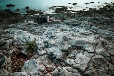 View of woman on rock by sea