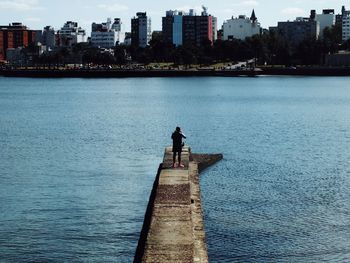 Rear view of man in sea against sky