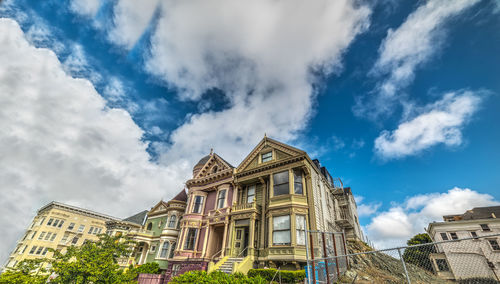 Low angle view of buildings against cloudy sky