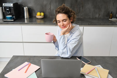 Portrait of young woman using digital tablet