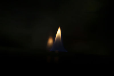 Close-up of lit candle in darkroom