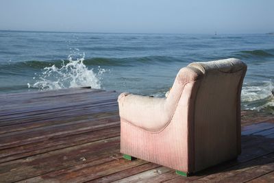 Lounge chairs on beach against sky