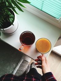 High angle view of woman holding tea cup on table