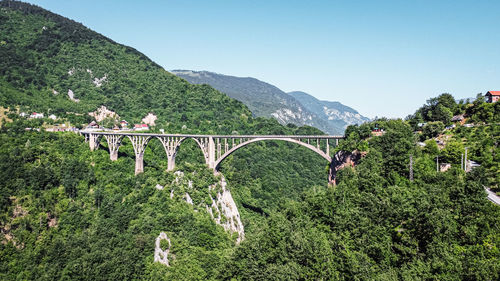 Bridge over mountains against clear sky