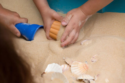 High angle view of baby hands on beach