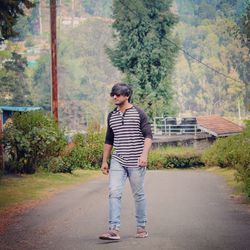 Full length of man walking on road against trees