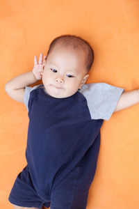 Close-up of toddler lying down on sofa at home