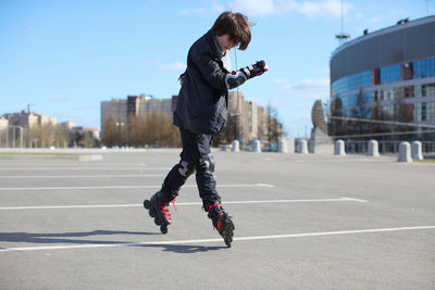 Full length of man skateboarding on city against sky