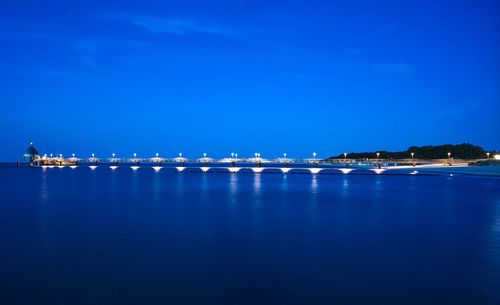 Scenic view of sea against blue sky at night