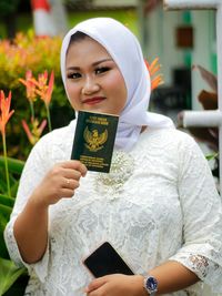 A young woman holding a proof of marriage in indonesia