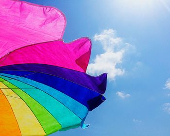 Low angle view of multi colored balloons against blue sky