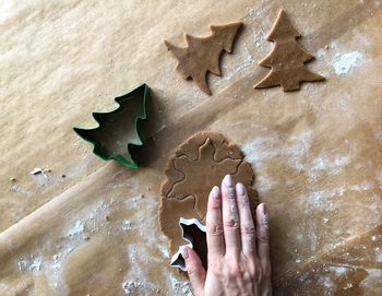 Cropped image of hand making cookies during christmas