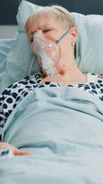 Low section of man sleeping on bed