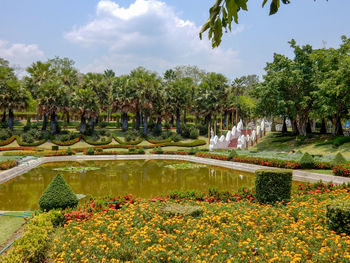 Scenic view of lake in park against cloudy sky