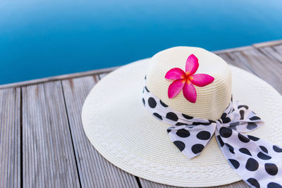 High angle view of pink flower on table by swimming pool