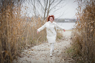 Pretty young woman in trendy white clothes poses in motion