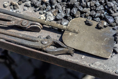High angle view of metal work tools and stones