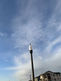 Low angle view of bird perching on building against sky