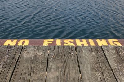 High angle view of text on pier at lake