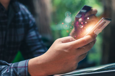 Midsection of man using mobile phone