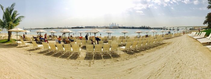 Panoramic view of people at beach against sky