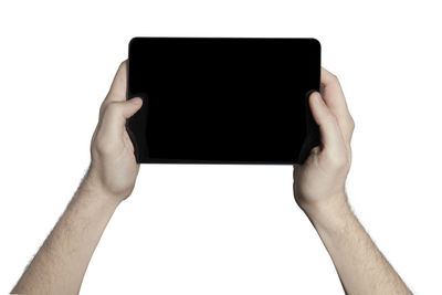 Low section of person holding smart phone against white background