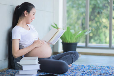 Young woman sitting on book