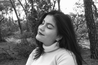 Portrait of young woman looking away in forest