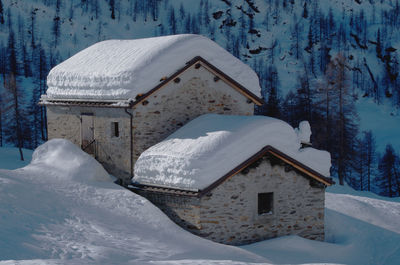 Snow covered cottage by building