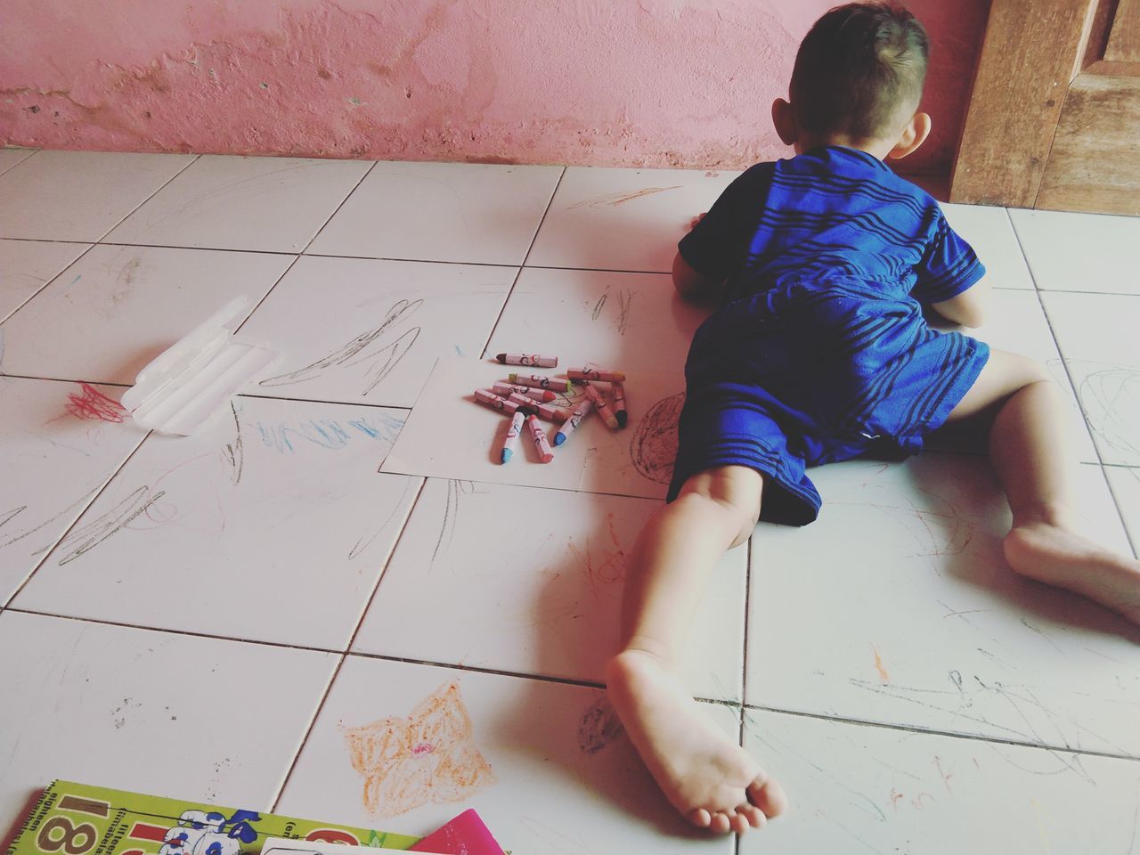 HIGH ANGLE VIEW OF CHILD ON TILED FLOOR AT HOME