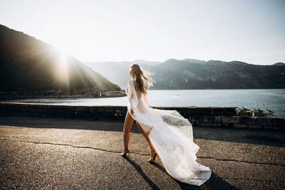 Woman standing on mountain against sky