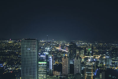 Illuminated cityscape against sky at night