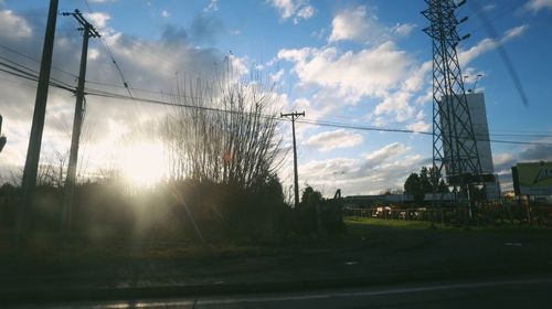 Electricity pylon against cloudy sky