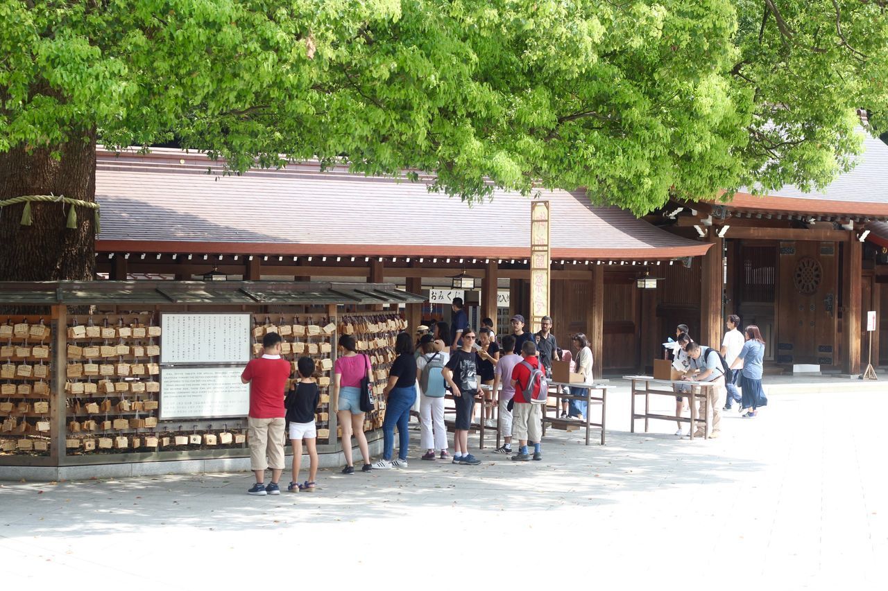 GROUP OF PEOPLE WALKING BY BUILDING