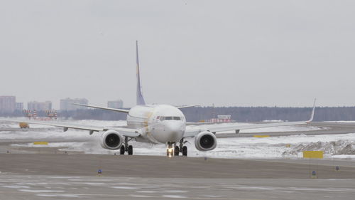 Airplane on runway against sky