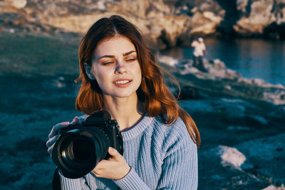 Young woman photographing with camera