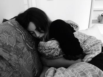 Rear view of women relaxing on bed at home