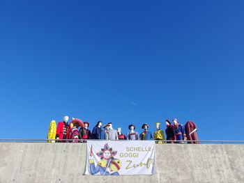 Group of people against clear blue sky