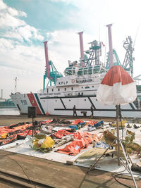 Boats moored at harbor against sky