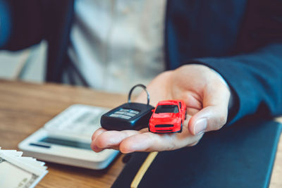 Close-up of man using mobile phone on table