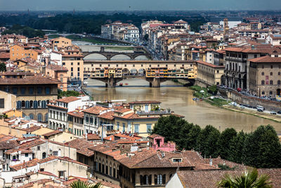 Ponte vecchio over arno river amidst town