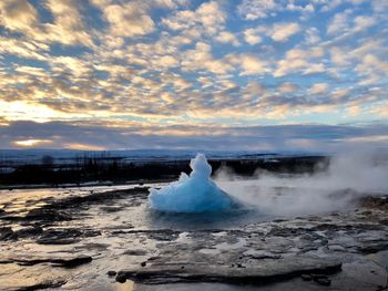 Scenic view of waterfall against sky during sunset