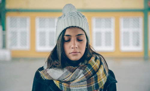 Portrait of a beautiful young woman with eyes closed in winter