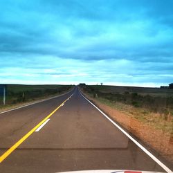 Country road against cloudy sky