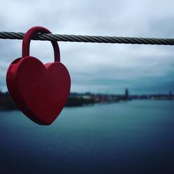 Close-up of padlocks on railing against sea