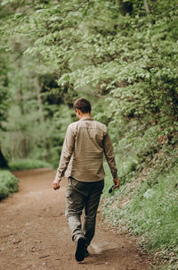 Rear view of man walking on road