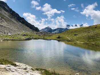 Scenic view of lake by mountains against sky