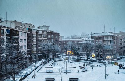 Houses in city against sky during winter