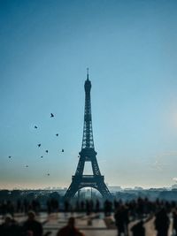 Communications tower in city against sky