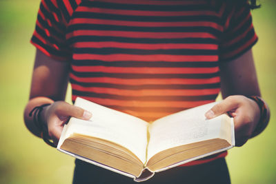 Midsection of woman reading book